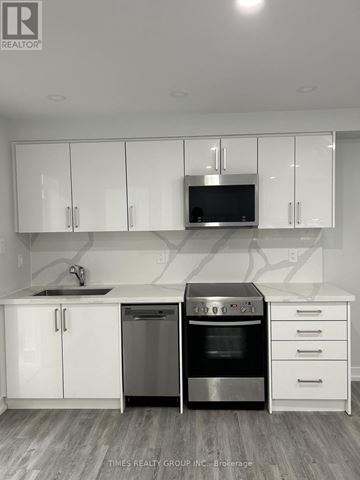 Toronto (Annex) multi-family for rent - A kitchen with white cabinets and a black microwave.