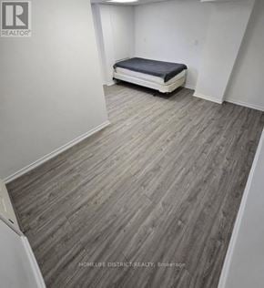 Ajax (Northwest Ajax) apartment for rent - A bedroom with a bed and wooden flooring.