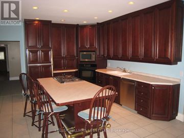 London East (East F) apartment for rent - A kitchen with wooden cabinets and a table with chairs.