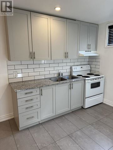Toronto (Bathurst Manor) apartment for rent - A kitchen with white cabinets and a white stove top oven.