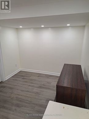 Toronto (Kennedy Park) apartment for rent - A room with a wooden bench and grey flooring.