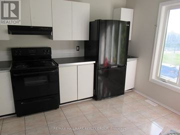 Ottawa townhouse for rent - A kitchen with black appliances and white cabinets.