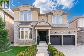 Vaughan (Kleinburg) apartment for rent - A large, luxurious house with a stone facade and a large front yard.