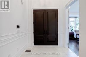 Vaughan (Kleinburg) apartment for rent - A white hallway with a black door and a logo on the wall.