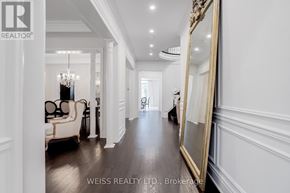Vaughan (Kleinburg) apartment for rent - A hallway with a chandelier, a mirror, and a chair.