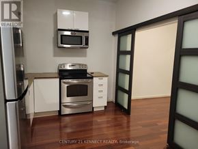 Toronto (Kensington-Chinatown) multi-family for rent - Empty room with shelves and a door.