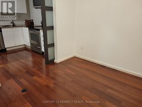 Toronto (Kensington-Chinatown) multi-family for rent - A room with wood flooring and a white door.