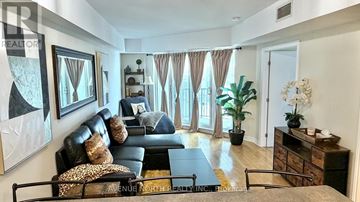 Ottawa condo for rent - A living room with a black couch and a coffee table.