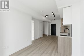 Toronto (Centennial Scarborough) condo for rent - A spacious, empty room with a kitchenette area and a sink.