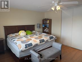 Richmond Hill (Devonsleigh) apartment for rent - A bedroom with a bed, chair, and a ceiling fan.
