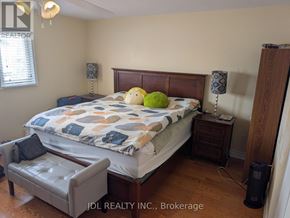 Richmond Hill (Devonsleigh) apartment for rent - A bedroom with a bed, nightstand, and chair.