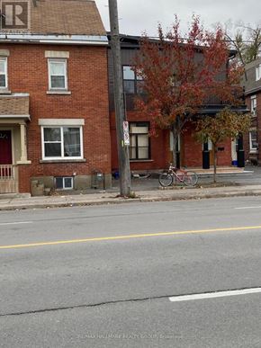 Ottawa townhouse for rent - A street view with a red brick building and a bicycle parked on the sidewalk.