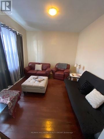 Ottawa townhouse for rent - A living room with a red couch, a white ottoman, and a black couch with pillows.