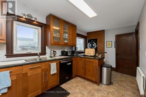 Halton Hills (Ac Acton) apartment for rent - A kitchen with wooden cabinets and a black countertop.