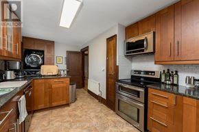 Halton Hills (Ac Acton) apartment for rent - A kitchen with brown cabinets and a black counter top.