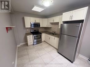 Oakville (Oo Old Oakville) apartment for rent - A kitchen with a refrigerator, microwave, oven, and cabinets.