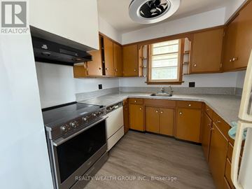 Whitchurch-Stouffville apartment for rent - A kitchen with wooden cabinets and a stainless steel oven.