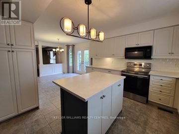 Barrie (Northwest) apartment for rent - A kitchen with white cabinets and a large island.