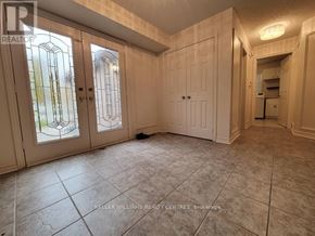 Barrie (Northwest) apartment for rent - A room with tiled flooring and a large window with a view of trees.