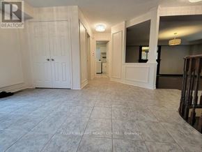 Barrie (Northwest) apartment for rent - A spacious room with a white door and a mirror on the wall.