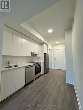 Toronto (Beechborough-Greenbrook) condo for rent - A modern kitchen with white cabinets and stainless steel appliances.
