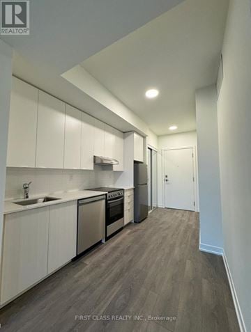 Toronto (Beechborough-Greenbrook) condo for rent - A modern kitchen with white cabinets and stainless steel appliances.