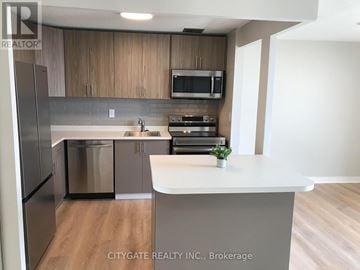 Mississauga (Lakeview) condo for rent - A kitchen with a white counter top and wooden cabinets.