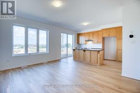 Kitchener apartment for rent - A spacious room with wooden floors and a large window overlooking a landscape.