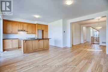 Kitchener apartment for rent - A well-lit kitchen with wooden cabinets and a large island.