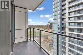 Kitchener condo for rent - A balcony with a glass railing and a view of a construction site.