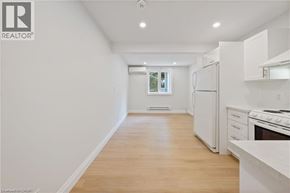 Kitchener apartment for rent - A white kitchen with a refrigerator, oven, and cabinets.