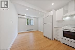 Kitchener apartment for rent - A well-lit kitchen with white appliances and wooden flooring.