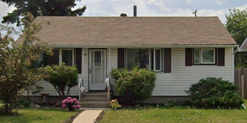Edmonton apartment for rent - A small white house with a brown door and a small porch.