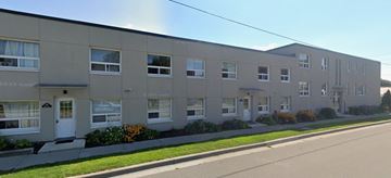 Oshawa apartment for rent - Apartment building with a green lawn in front.