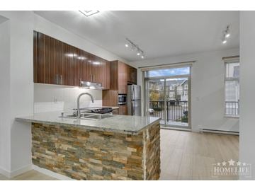 Abbotsford townhouse for rent - A kitchen with a stone counter and wooden cabinets.