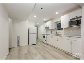 Chilliwack apartment for rent - A kitchen with white cabinets and appliances in a white room.