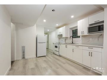Chilliwack apartment for rent - A kitchen with white cabinets and appliances in a white room.