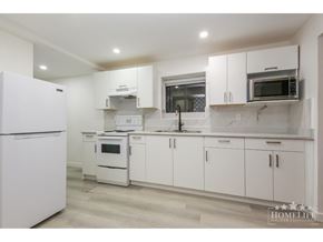 Chilliwack apartment for rent - A white kitchen with a refrigerator on the left and a microwave on the right.