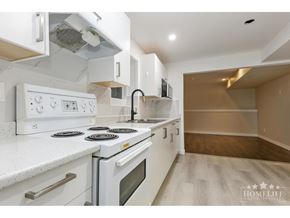 Chilliwack apartment for rent - A white kitchen with a stove top oven and a microwave.