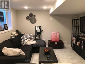 Ottawa apartment for rent - A living room with a black couch, a coffee table, and a pink box on a side table.