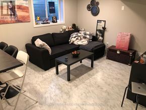 Ottawa apartment for rent - A black couch with a white pillow and a black and white checkered blanket is in the center of the room.