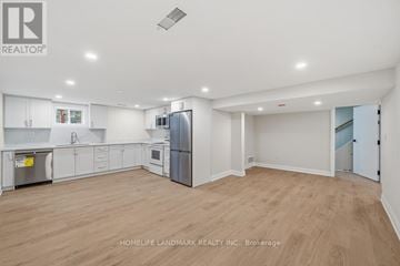 Toronto (Bathurst Manor) apartment for rent - A spacious kitchen with white cabinets and a refrigerator.