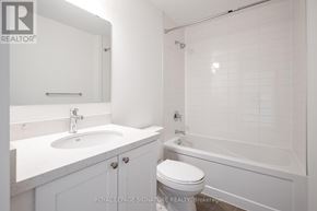 Clarington (Bowmanville) condo for rent - A white bathroom with a sink, toilet and bathtub.