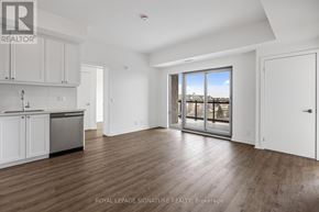 Clarington (Bowmanville) condo for rent - A spacious room with wooden flooring and a large window overlooking a body of water.