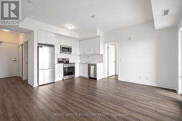 Clarington (Bowmanville) condo for rent - A spacious kitchen with white cabinets and stainless steel appliances.