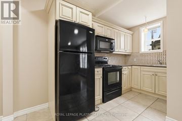 Hamilton (St. Clair) multi-family for rent - A kitchen with a black fridge and microwave.