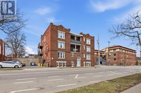 Hamilton (St. Clair) multi-family for rent - A street view of a multi-story brick building with a car parked in front.