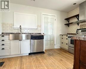 Cobourg apartment for rent - A kitchen with white cabinets and a stainless steel dishwasher.