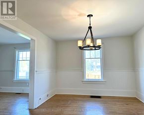 Cobourg apartment for rent - A well-lit room with a chandelier and two windows.