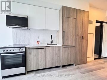 Toronto (Centennial Scarborough) condo for rent - A modern kitchen with wooden cabinets and a stainless steel oven.
